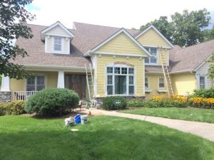 exterior painting a yellow house